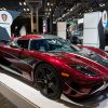 Three-quarter angle of a deep red Koenigsegg Regera on a platform at the New York Auto Show floor in 2018