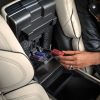 A human hand prepares to plug a Lincoln Digital Scent cartridge into the center console of a 2024 Lincoln Nautilus