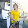 Yellow-shirted woman fills up car with gas