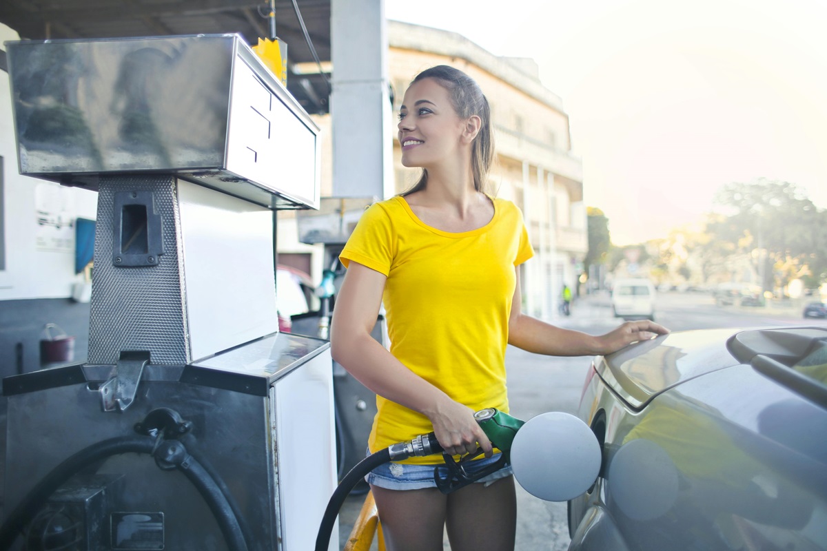 Yellow-shirted woman fills up car with gas