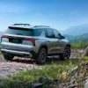 Passenger-side rear 3/4 view of 2024 Chevrolet Traverse Z71 in Sterling Gray Metallic parked on a gravel road with forested hills in the background