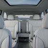 Looking back from the front seat, a view of the 2025 Buick Enclave Avenir's three seating rows and panoramic sunroof