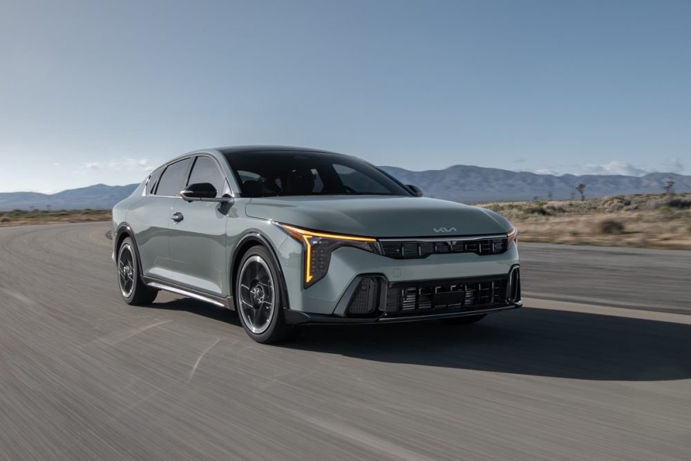 Exterior front 3/4 shot of the 2025 Kia K4 driving on a road