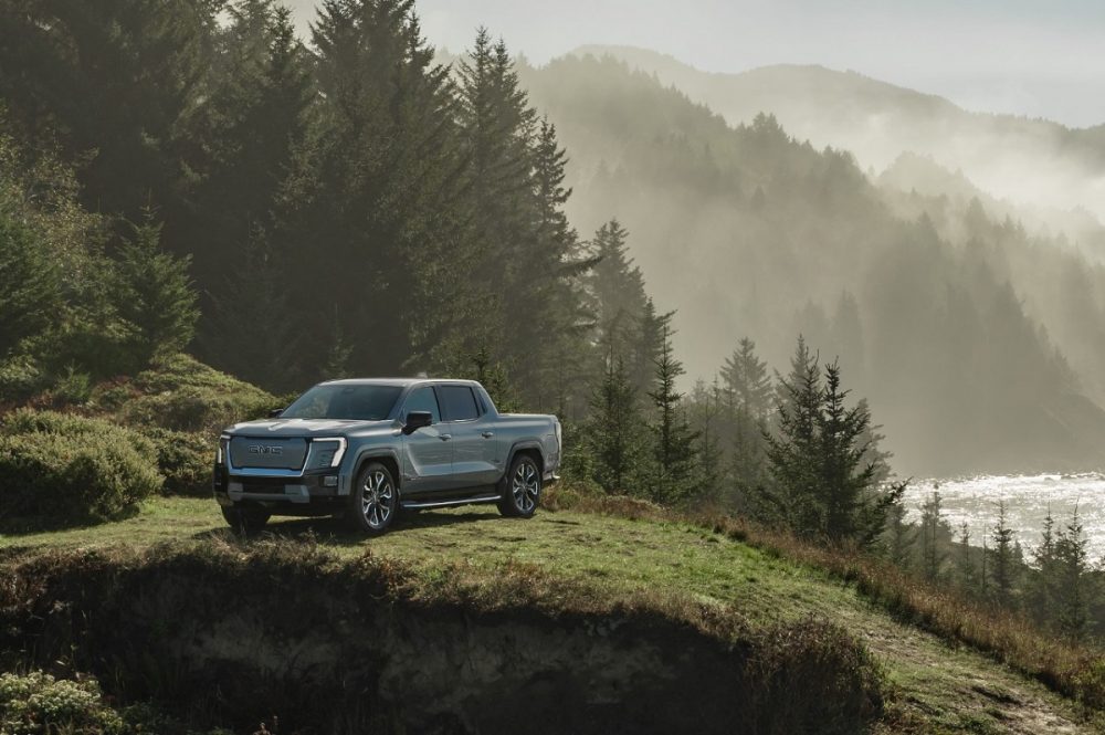 Front 3/4 view of the 2024 GMC Sierra EV Denali Edition 1 on a wooded cliff
