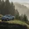 Front 3/4 view of the 2024 GMC Sierra EV Denali Edition 1 on a wooded cliff