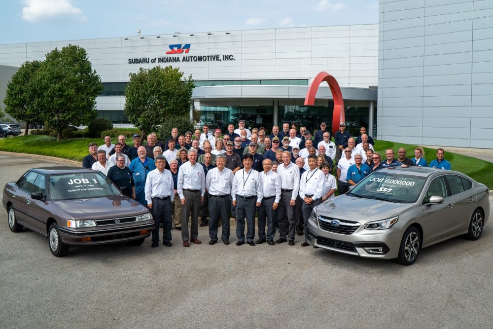 Employees at Subaru of Indiana pose with a 1990 Legacy and a 2020 Legacy
