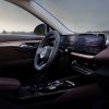 The steering wheel, 30-inch screen, and Garnet upholstery inside the 2024 Buick Envision Sport Touring, shown from the passenger’s seat