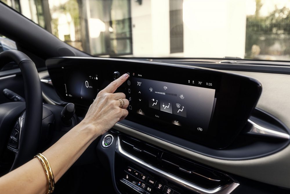 Side view of a driver's finger tapping the 19-inch ultrawide display inside the 2024 Buick Envista Avenir