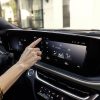 Side view of a driver's finger tapping the 19-inch ultrawide display inside the 2024 Buick Envista Avenir