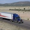 A semi truck and trailer driving down a divided highway in Arizona