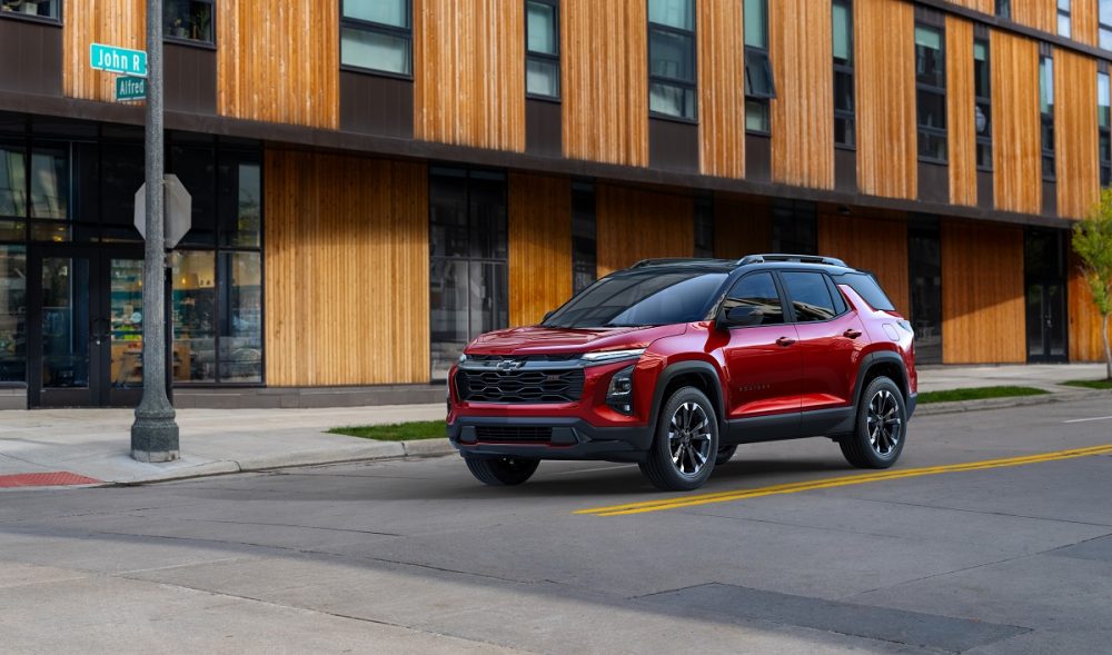 Front 3/4 view of a 2025 Chevrolet Equinox RS in Radiant Red Tintcoat on a city street in front of a building