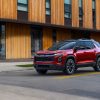 Front 3/4 view of a 2025 Chevrolet Equinox RS in Radiant Red Tintcoat on a city street in front of a building