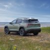 Rear 3/4 view of a 2025 Chevrolet Equinox ACTIV in Cacti Green parked in front of a lake