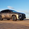 A front side view of the 2025 Hyundai Tucson driving down a road with blue sky in the background