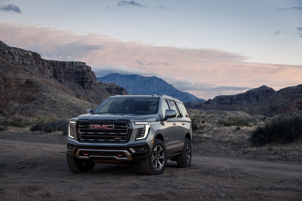 Front 3/4 view of the 2025 GMC Yukon AT4 Ultimate against a rocky backdrop at sunset