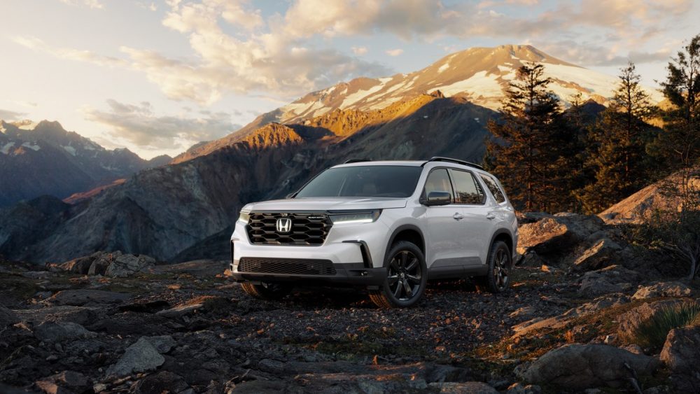 Front side view of a white 2025 Honda Pilot Black Edition against a mountain backdrop