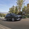 Front 3/4 view of the 2025 Chevrolet Blazer 3LT in Black, driving in front of a home.