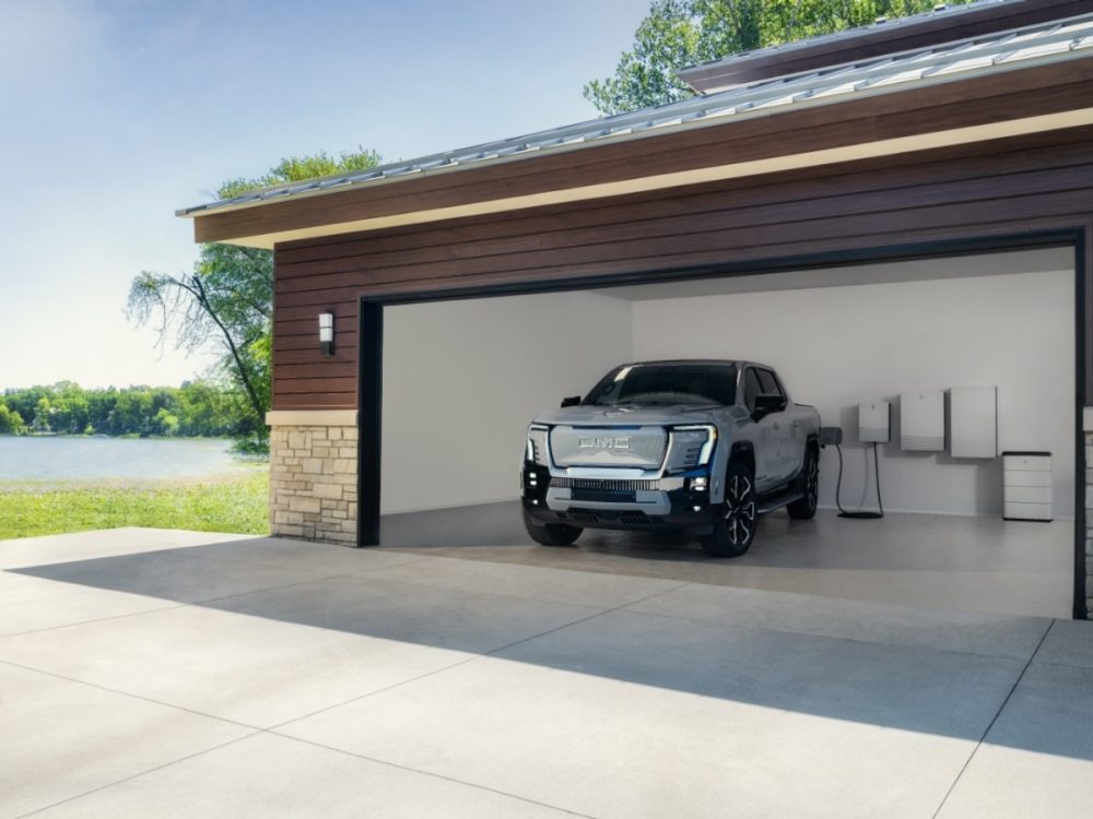 A front view of the 2025 GMC Sierra EV Denali as it charges inside a garage