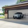 A front view of the 2025 GMC Sierra EV Denali as it charges inside a garage