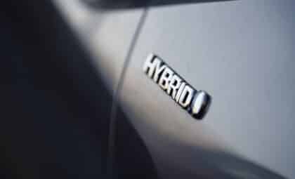 Close-up view of the hybrid logo on a Toyota plugin hybrid car