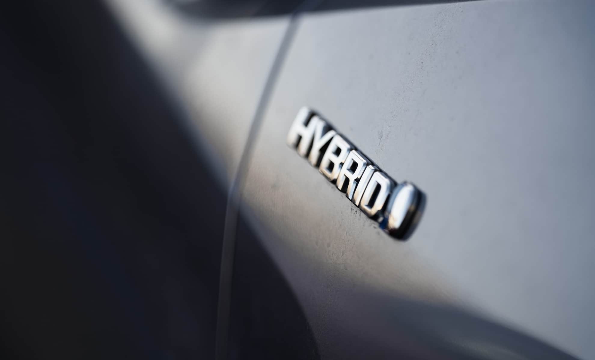 Close-up view of the hybrid logo on a Toyota plugin hybrid car